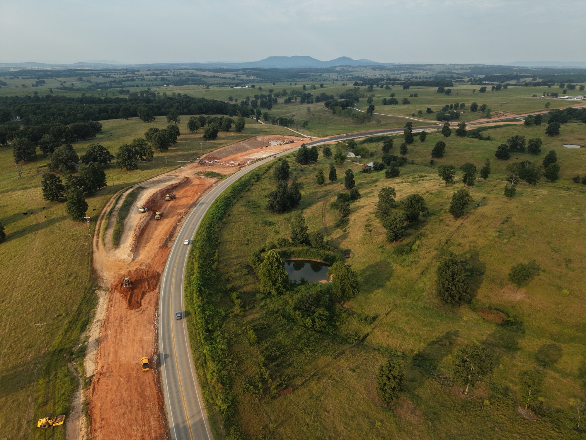 Aerial view of a rural highway realignment and road-widening project in the Ozark foothills